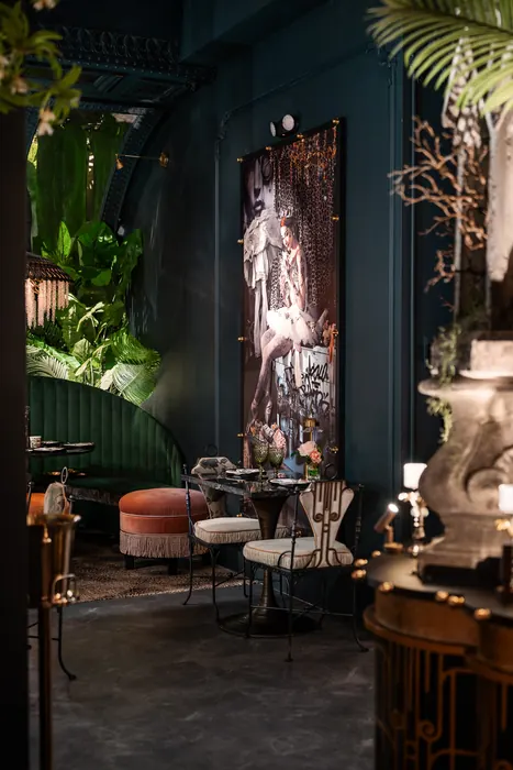 Sculptural statuary and framed art beside a bare decorative tree