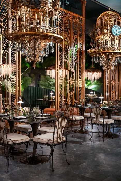 Crystal chandeliers and gilded screens above set dining tables