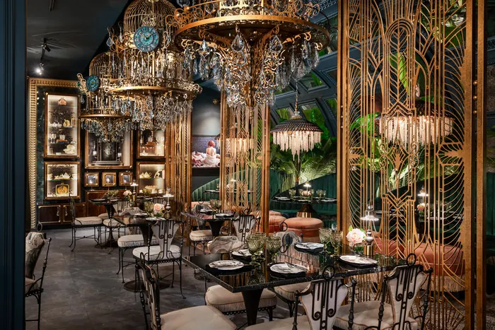 The dining room's full span, gilded screens and chandeliers receding into the room