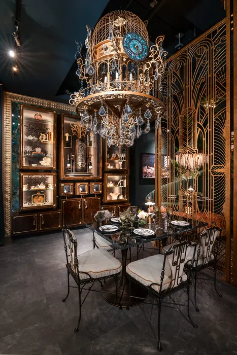 A set table before illuminated curio cabinets and a crystal chandelier