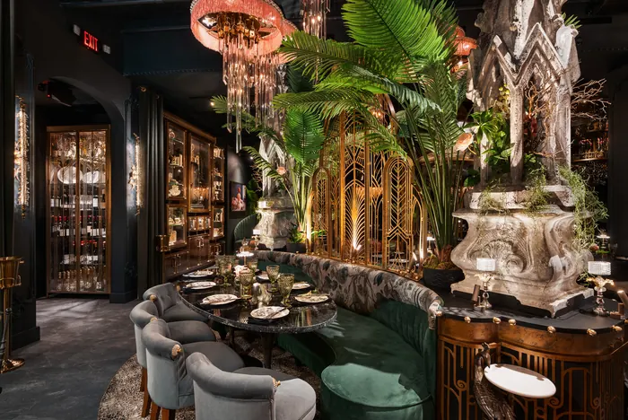 Dining room with the sculptural bare tree and palms rising between tables