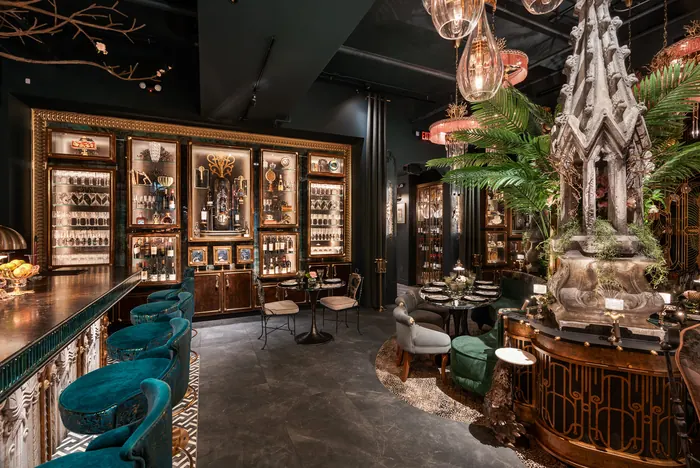 Backlit bottle shelves and the sculptural tree beside the bar