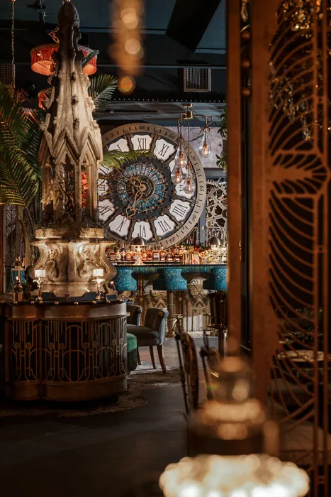 The mosaic clock glimpsed through a gilded screen from the dining room